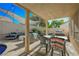 Covered outdoor dining area with lounge seating, overlooking the backyard pool at 841 Glitter Glen Ct, Las Vegas, NV 89123