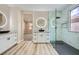 Stylish bathroom with a glass enclosed shower, dual vanities and modern lighting fixtures at 9272 W Viking Rd, Las Vegas, NV 89147