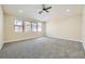 Large bedroom with plush carpeting, three windows, and a ceiling fan at 9272 W Viking Rd, Las Vegas, NV 89147