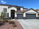 Charming two-story home featuring a spacious three-car garage, desert landscaping, and inviting entrance at 9272 W Viking Rd, Las Vegas, NV 89147