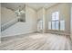 Spacious living room featuring hardwood floors, staircase, soaring ceilings, and large windows at 9272 W Viking Rd, Las Vegas, NV 89147