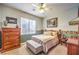 Cozy bedroom with a wooden bed frame, neutral tones, and a ceiling fan at 9378 Chateau St Jean Dr, Las Vegas, NV 89123
