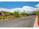 A serene community entrance with a mountain backdrop, features lush greenery and a welcoming road at 97 Sarabeth St, Las Vegas, NV 89138