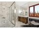 Upstairs guest bathroom featuring marble accents and a luxurious soaking tub next to a window at 9940 Orient Express Ct, Las Vegas, NV 89145
