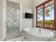 Bright bathroom featuring a freestanding tub and glass-enclosed shower with a scenic outdoor view at 9940 Orient Express Ct, Las Vegas, NV 89145