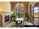 Cozy breakfast nook featuring fireplace, stone surround, and backyard view at 9940 Orient Express Ct, Las Vegas, NV 89145