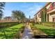 Lush formal garden with manicured hedges, mature trees, and a verdant lawn at 9940 Orient Express Ct, Las Vegas, NV 89145