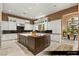 Spacious kitchen with large island, white cabinets, granite counters and travertine floors at 9940 Orient Express Ct, Las Vegas, NV 89145