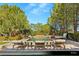 A luxury pool is surrounded by lounge furniture, lush trees, and manicured landscaping at 9940 Orient Express Ct, Las Vegas, NV 89145