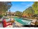 A luxury swimming pool with built-in jacuzzi is surrounded by lounge furniture and lush landscaping at 9940 Orient Express Ct, Las Vegas, NV 89145