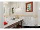 Elegant powder room with marble countertop, marble backsplash, decorative mirror, and vintage-style faucet at 9940 Orient Express Ct, Las Vegas, NV 89145