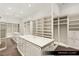 Spacious primary closet with custom shelving and a marble island with drawers at 9940 Orient Express Ct, Las Vegas, NV 89145