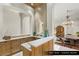 Convenient wet bar with custom cabinets, marble counters, and stylish mirror at 9940 Orient Express Ct, Las Vegas, NV 89145