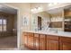 Well-lit bathroom with double sinks, wood cabinets, and modern fixtures at 997 Moonlight Terrace Run, Mesquite, NV 89034