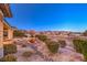 Desert landscaped backyard featuring shrubs, trees and a stone waterfall feature at 1809 Prichard Ave, Henderson, NV 89052