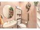 Cozy bathroom featuring a pedestal sink, toilet with grab bar, and built-in shelving for ample storage at 1809 Prichard Ave, Henderson, NV 89052