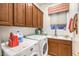 Functional laundry room with front loading machines, sink, and upper cabinets at 1809 Prichard Ave, Henderson, NV 89052