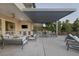 Expansive covered patio with an outdoor kitchen, bar seating, comfortable lounge furniture, and ceiling fan at 2171 King Crest Ct, Henderson, NV 89052