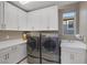 Well-lit laundry room features white cabinetry, counter space, sink, and modern washer and dryer units at 2171 King Crest Ct, Henderson, NV 89052
