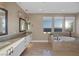 Main bathroom with dual sinks, decorative lighting, a soaking tub, and three windows at 2171 King Crest Ct, Henderson, NV 89052