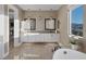 Bright main bathroom with dual sinks, white cabinetry, a soaking tub, and natural light at 2171 King Crest Ct, Henderson, NV 89052