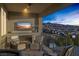 Cozy outdoor patio with fireplace, comfortable seating, television, and beautiful sunset views at 2171 King Crest Ct, Henderson, NV 89052