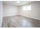 Large bedroom with wood-look floors, neutral walls, natural light, and a ceiling light at 223 Greenbriar Townhouse Way, Las Vegas, NV 89121