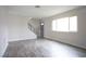 Living room with gray wood laminate flooring, staircase, and a large window at 223 Greenbriar Townhouse Way, Las Vegas, NV 89121