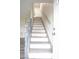 Inviting stairway featuring white risers, wood-look treads, and gray handrail at 223 Greenbriar Townhouse Way, Las Vegas, NV 89121