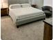Cozy bedroom with neutral carpeting, gray upholstered bedframe, and side tables at 2379 Albury Ave, North Las Vegas, NV 89086