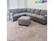Comfortable living room with a large sectional sofa, ottoman, and neutral-toned carpet at 2379 Albury Ave, North Las Vegas, NV 89086