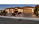 Well-maintained stucco home featuring brick accents and desert landscaping at 2388 Orangeburg Pl, Henderson, NV 89044