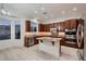 Kitchen featuring wood cabinets, stainless appliances, granite counters, and breakfast nook with mountain views at 2388 Orangeburg Pl, Henderson, NV 89044