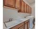 Laundry room with wood cabinets, white counters, a sink and a washer and dryer at 2388 Orangeburg Pl, Henderson, NV 89044