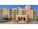 Exterior of a yellow and peach building with an arched entry way and a water feature in front at 30 Strada Di Villaggio # 409, Henderson, NV 89011