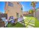 Inviting backyard features an outdoor seating area with a table and artificial grass at 4125 Glenfield Cir, Las Vegas, NV 89129