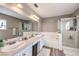 Well-lit bathroom features a double vanity, soaking tub, and glass-enclosed shower at 4125 Glenfield Cir, Las Vegas, NV 89129