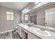 Bright bathroom with dual sinks, large mirror, wood-look flooring, and natural light at 4125 Glenfield Cir, Las Vegas, NV 89129