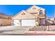Attractive stucco home with a two-car garage, tiled roof, and desert-friendly landscaping at 4125 Glenfield Cir, Las Vegas, NV 89129