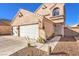 Two-story stucco home showcasing a two-car garage, tiled roof, and low-maintenance landscaping at 4125 Glenfield Cir, Las Vegas, NV 89129