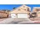 Charming two-story stucco home featuring a two-car garage and easy-care desert landscaping at 4125 Glenfield Cir, Las Vegas, NV 89129