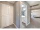 Hallway view of bathroom and bedroom with carpeted floors and white bathroom cabinetry at 4125 Glenfield Cir, Las Vegas, NV 89129