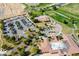 This aerial view captures the community's clubhouse, golf course, and parking, surrounded by beautiful landscaping and desert scenery at 4571 S Via Roma Dr, Pahrump, NV 89061