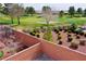 View of a backyard with brick walls, manicured bushes, and a view of the community golf course at 4571 S Via Roma Dr, Pahrump, NV 89061