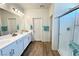 Bathroom boasting double sinks, walk-in shower with glass door, and wood-look floors at 4571 S Via Roma Dr, Pahrump, NV 89061