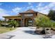 The Grill Room and Bar's welcoming entrance, with its stone archway, is complemented by lush landscaping and desert scenery at 4571 S Via Roma Dr, Pahrump, NV 89061