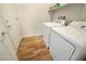 Efficient laundry room with appliances, wood-look flooring, and storage shelf at 4571 S Via Roma Dr, Pahrump, NV 89061