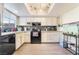 The kitchen features white cabinets, wood floors, and black appliances at 466 Las Casitas Way, Las Vegas, NV 89121