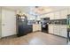 The kitchen features white cabinets, wood floors, and black appliances at 466 Las Casitas Way, Las Vegas, NV 89121