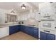 Kitchen area features white and blue cabinets and modern appliances at 5277 Masters Ave, Las Vegas, NV 89142